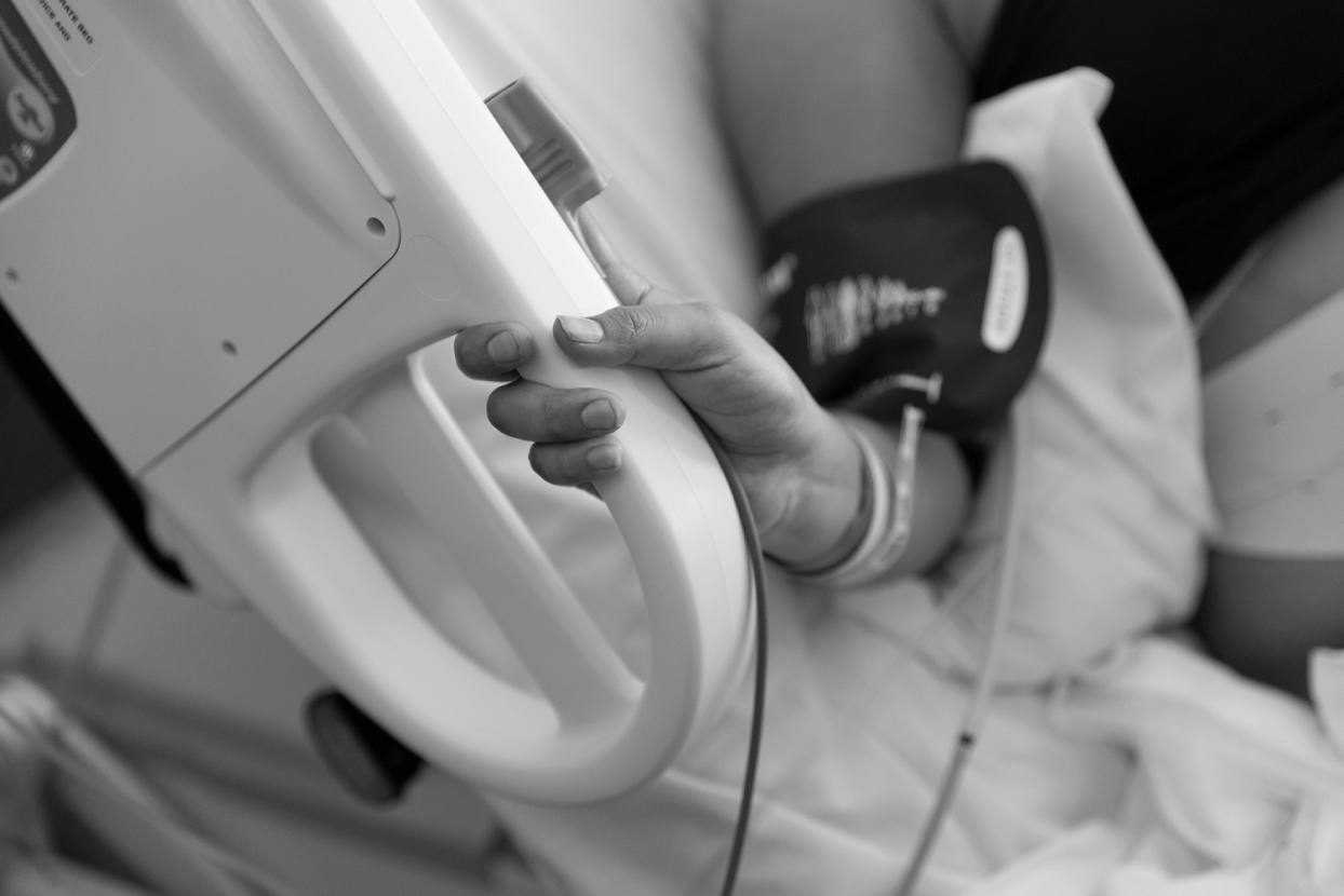 Laboring mother holding onto hospital bed during contractions