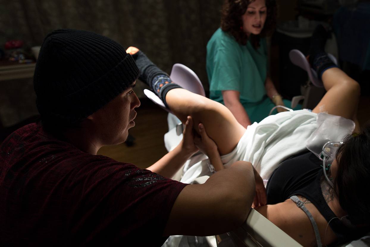 Dad comforting mom during birth at Denver Health Hospital